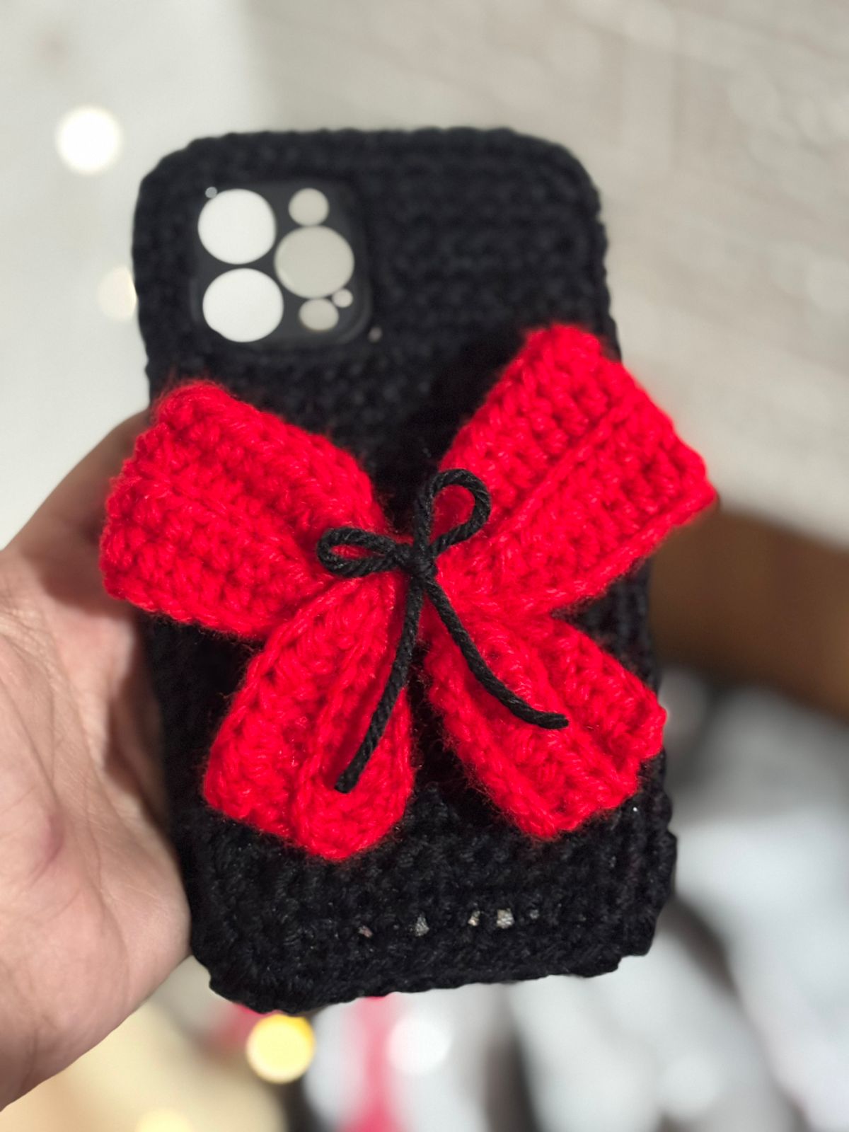 Handmade black crochet phone case with red bow aesthetic wool design
