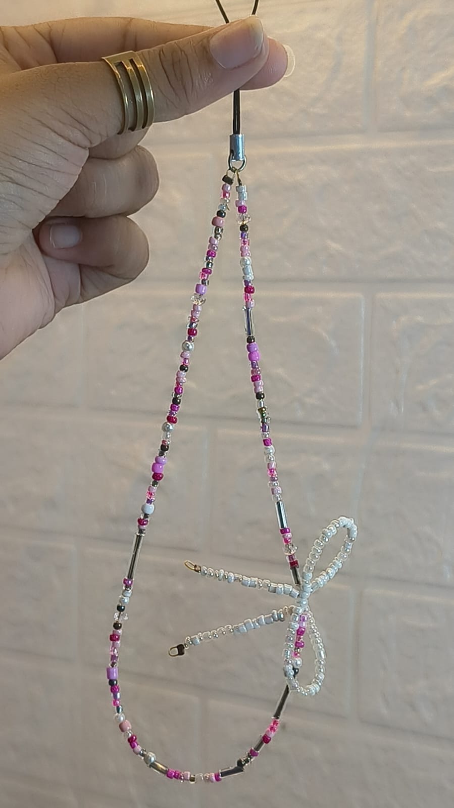 Handmade Pink Bow Beaded Phone Charm Strap featuring pink, white and silver beads with a cute bow charm, compatible with iPhone, Samsung and all smartphones.