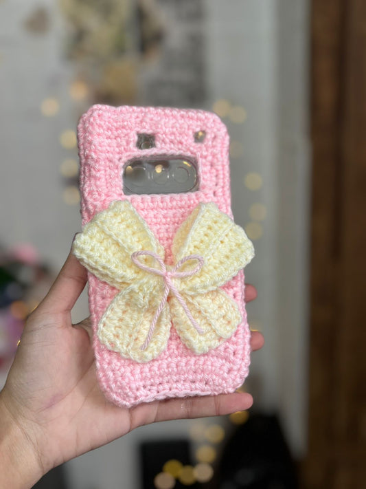 Handmade pink crochet bow phone case with soft wool texture and cute aesthetic design