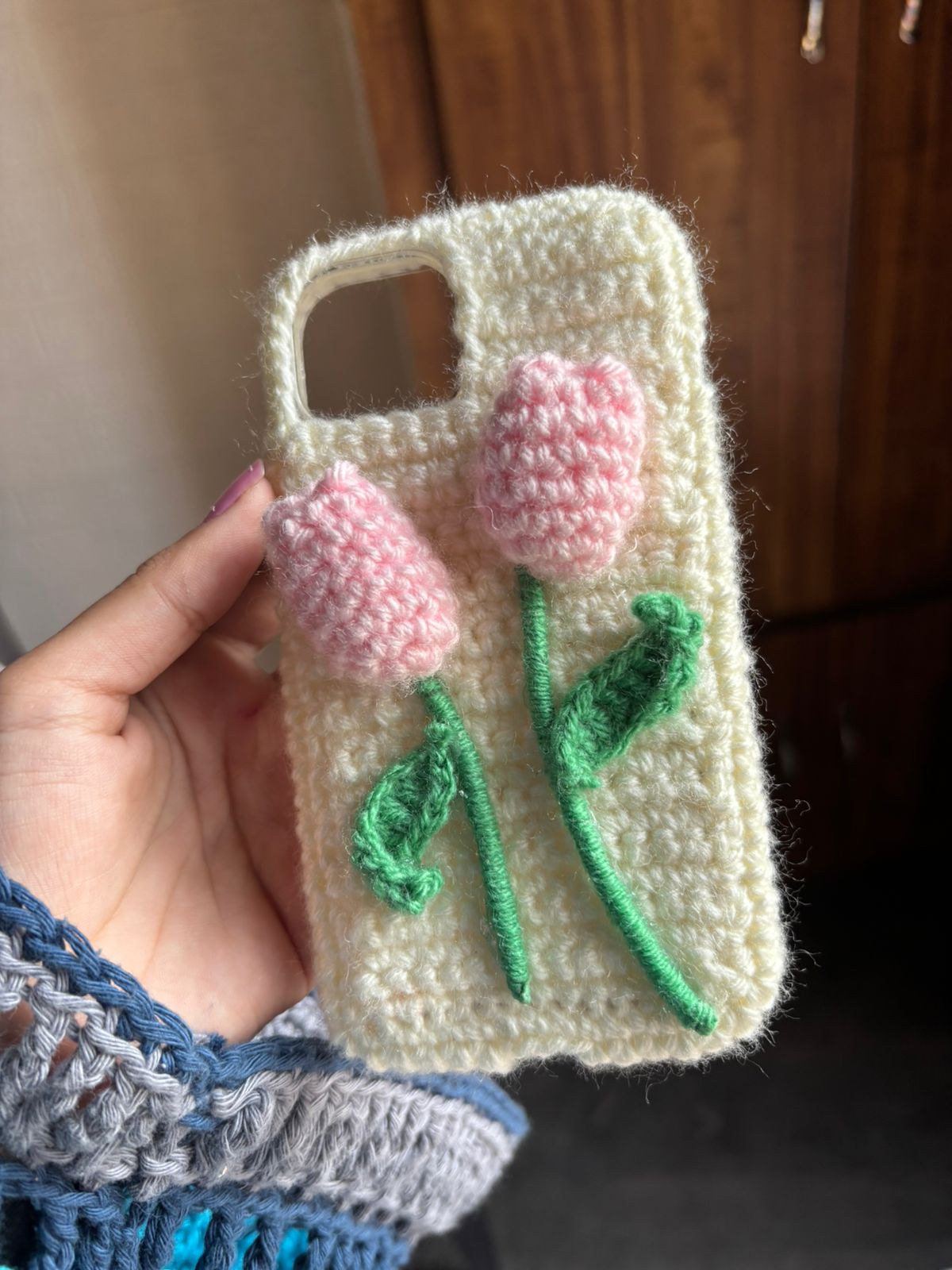 Handmade crochet flower phone case with pink 3D flowers and soft wool aesthetic design