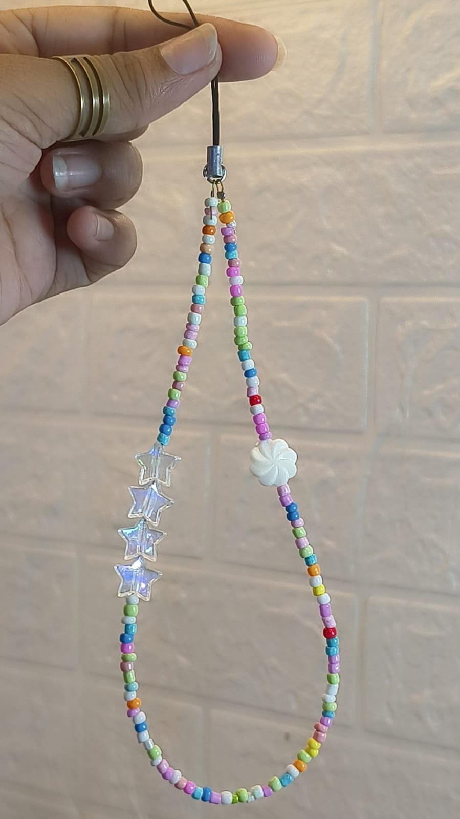 Handmade rainbow star beaded phone charm strap with colorful beads, transparent star charms and white flower bead for smartphones, handbags and keys.